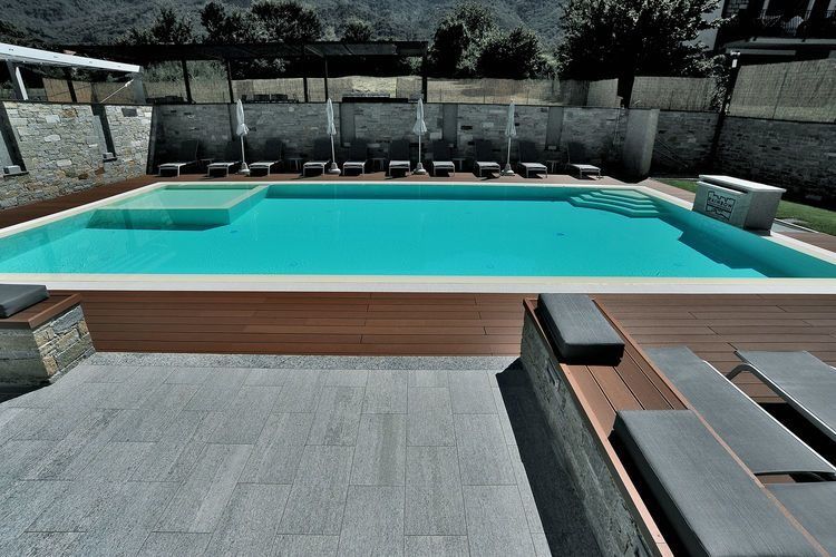 Una gran piscina rodeada de sillas y sombrillas.