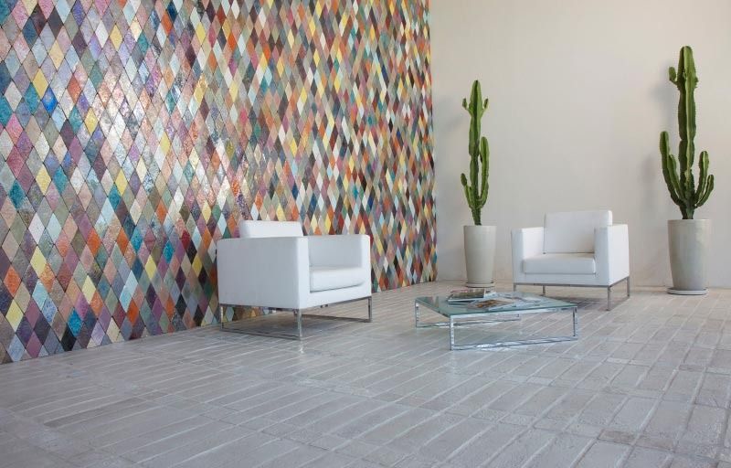 Una sala de estar con dos sillas, una mesa de café y una pared colorida.