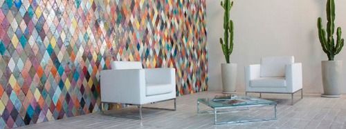 Una sala de estar con dos sillas, una mesa de café y una pared colorida.