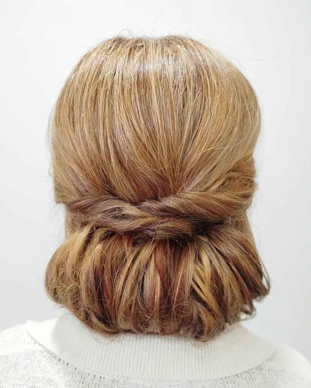 Vista posterior del cabello castaño claro peinado en un moño bajo y retorcido.