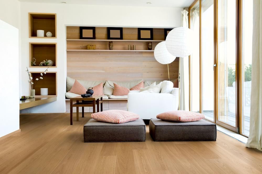 Modernes Wohnzimmer mit hellen Holzböden, Einbauregalen und großen Fenstern.