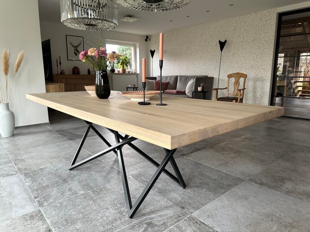 Heller Esstisch aus Holz mit schwarzen Metallbeinen in einem modernen Esszimmer.