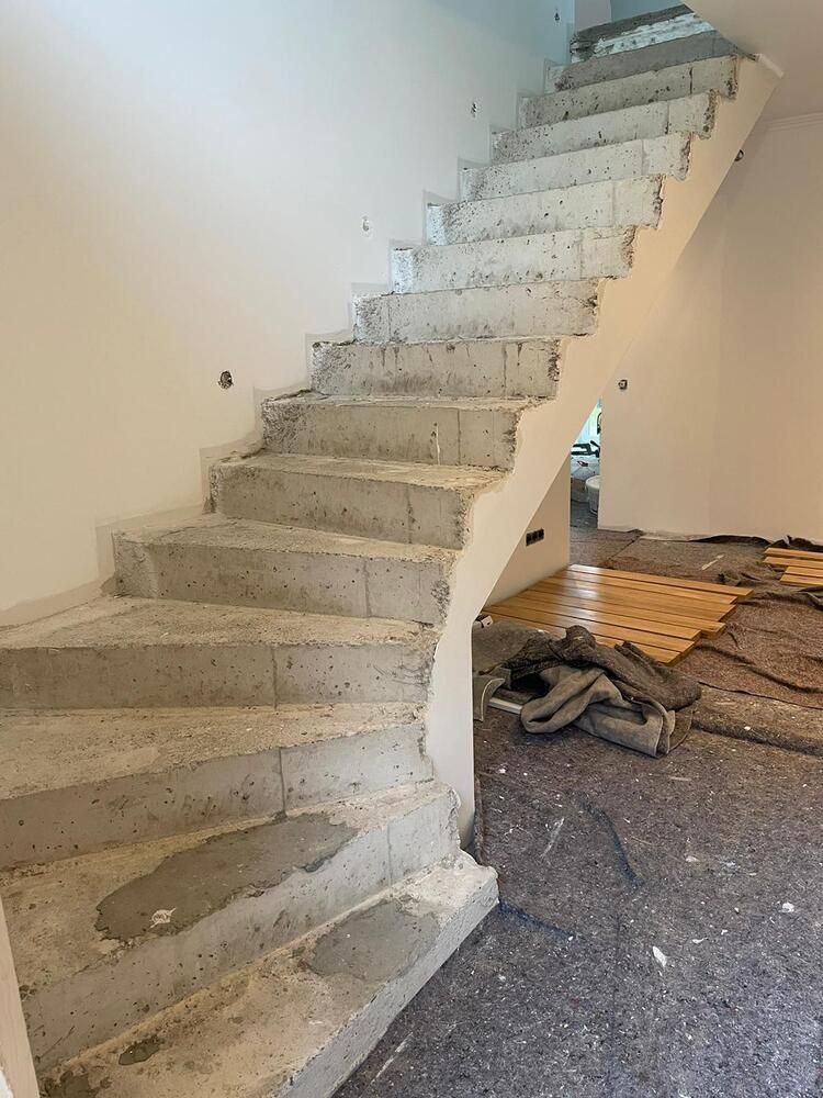 Im Bau befindliche Betontreppe mit sichtbaren Stufen und unfertiger Wand.