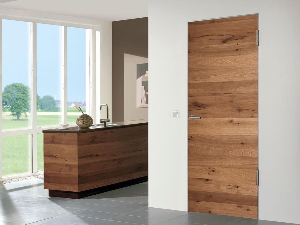 Holztür in einem modernen Interieur, neben einer weißen Wand.