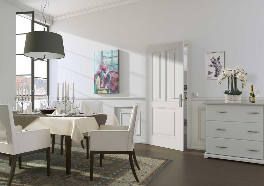 Esszimmer mit gedecktem Tisch, weißen Stühlen und einer Kommode. Kunstwerke und eine Hängelampe sind ebenfalls vorhanden.