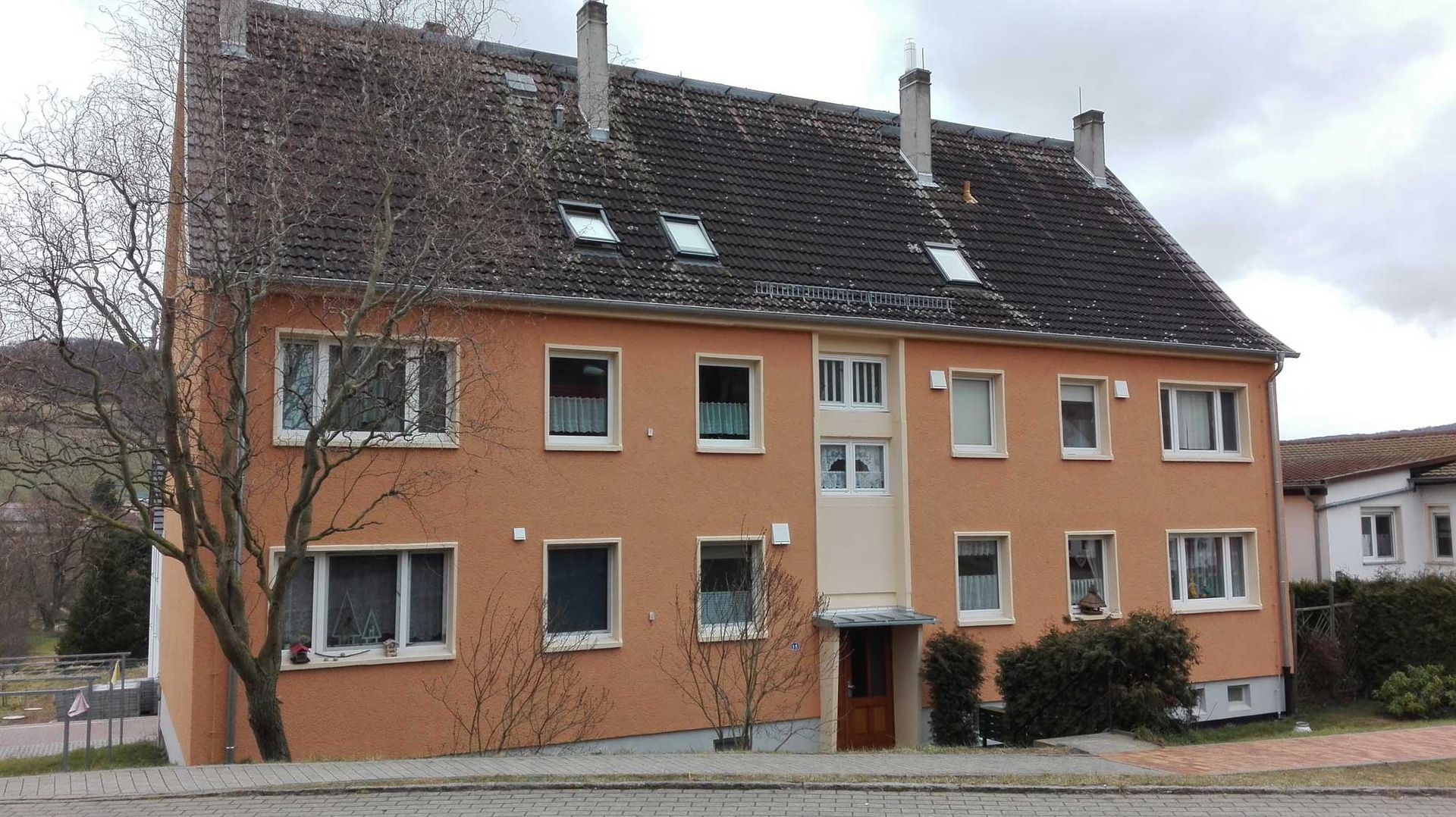 Ein großes orangefarbenes Gebäude mit einem schwarzen Dach