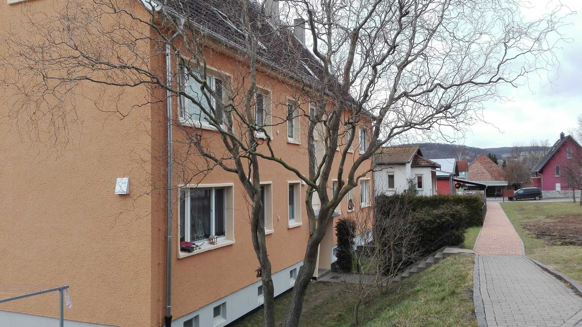 Ein großes orangefarbenes Gebäude mit einem Baum davor.