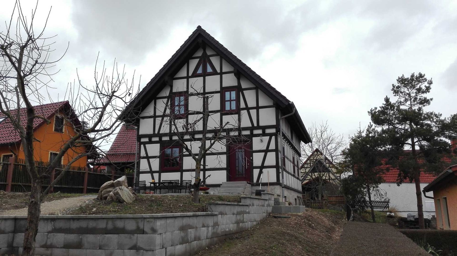 Ein schwarz-weißes Haus mit einer roten Tür