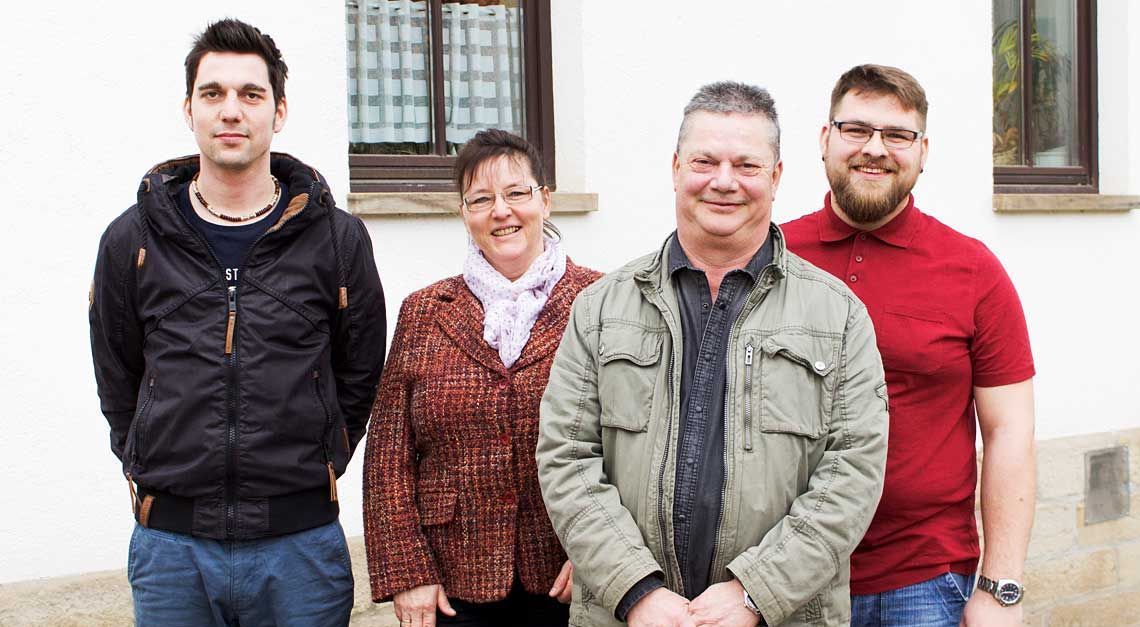Eine Gruppe von Menschen posiert vor einem Gebäude für ein Foto.