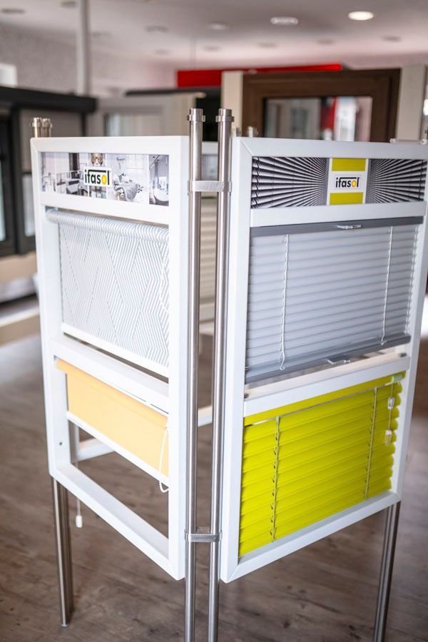 Eine Ausstellung unterschiedlicher Jalousietypen in einem Geschäft.