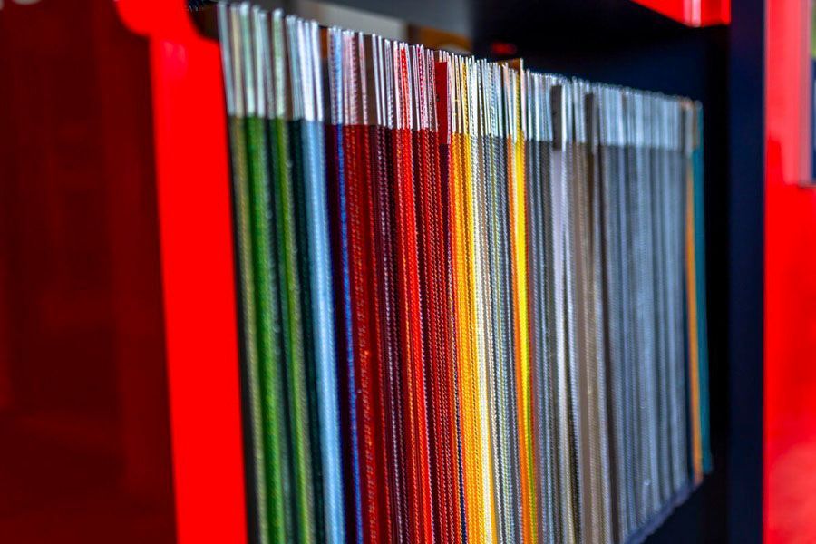 Eine Reihe bunter Bücher auf einem roten Regal.