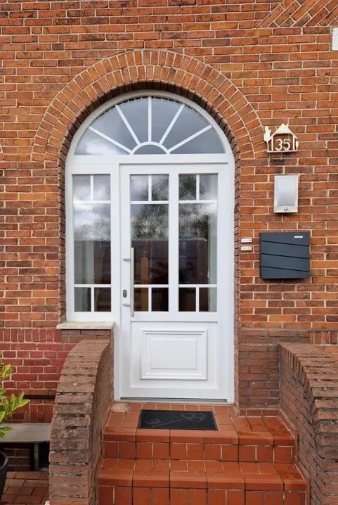 Die Eingangstür eines Backsteingebäudes mit einer weißen Tür
