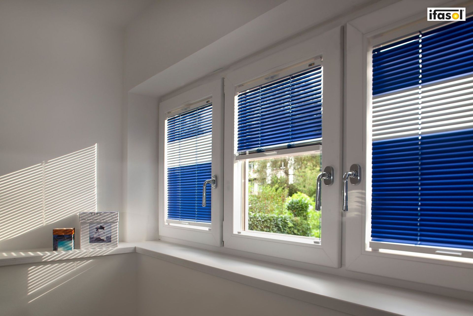 Ein Fenster mit blauen und weißen Jalousien