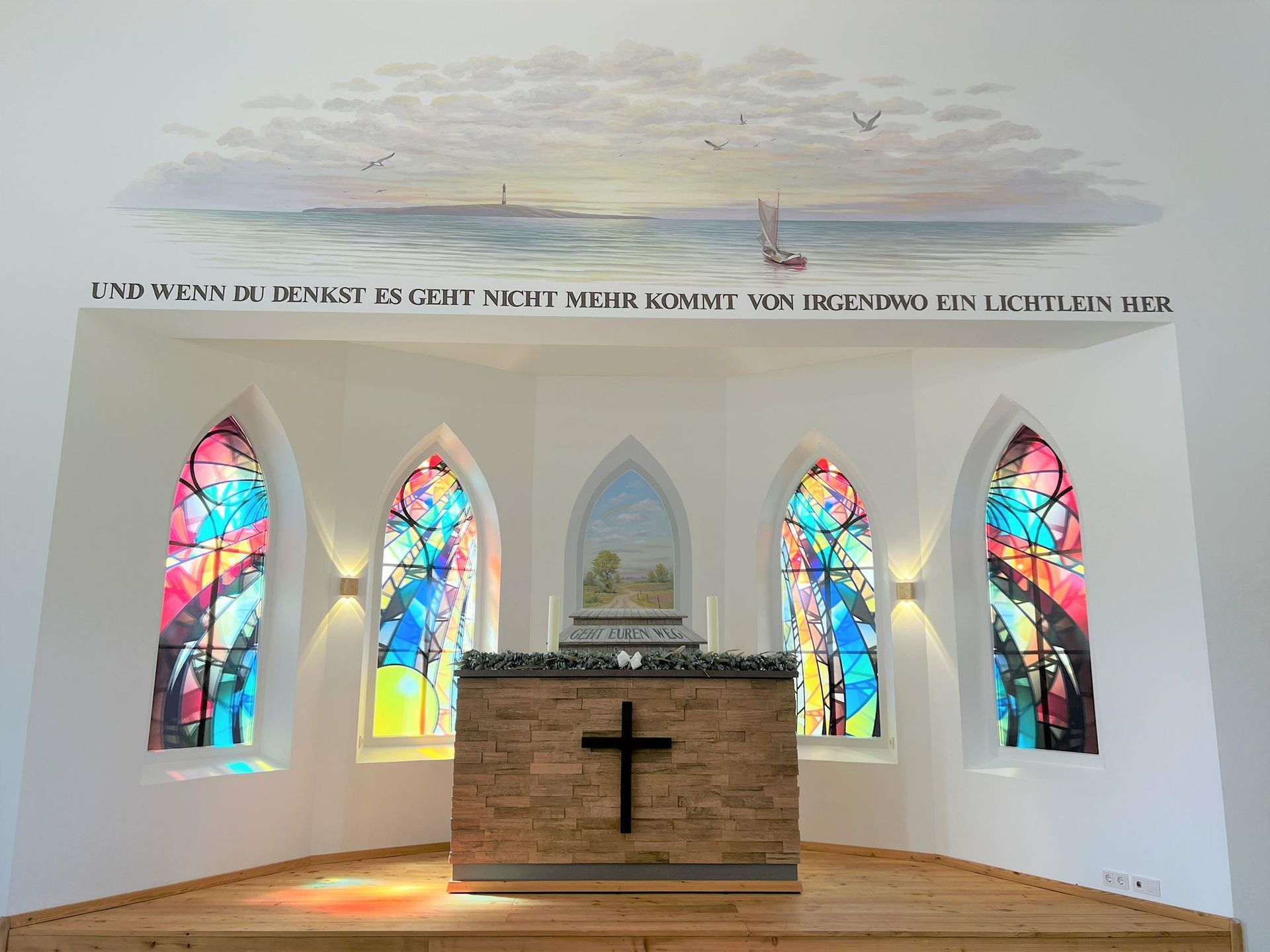 Eine Kirche mit Buntglasfenstern und einem Kreuz auf dem Altar