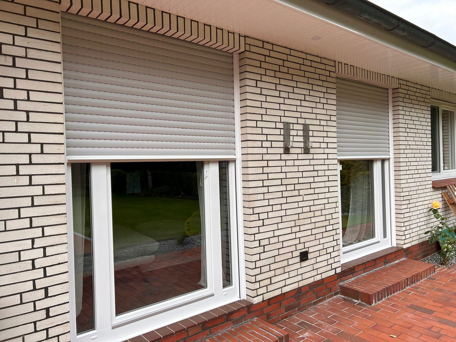 Ein weißes Backsteinhaus mit weißen Fensterläden.