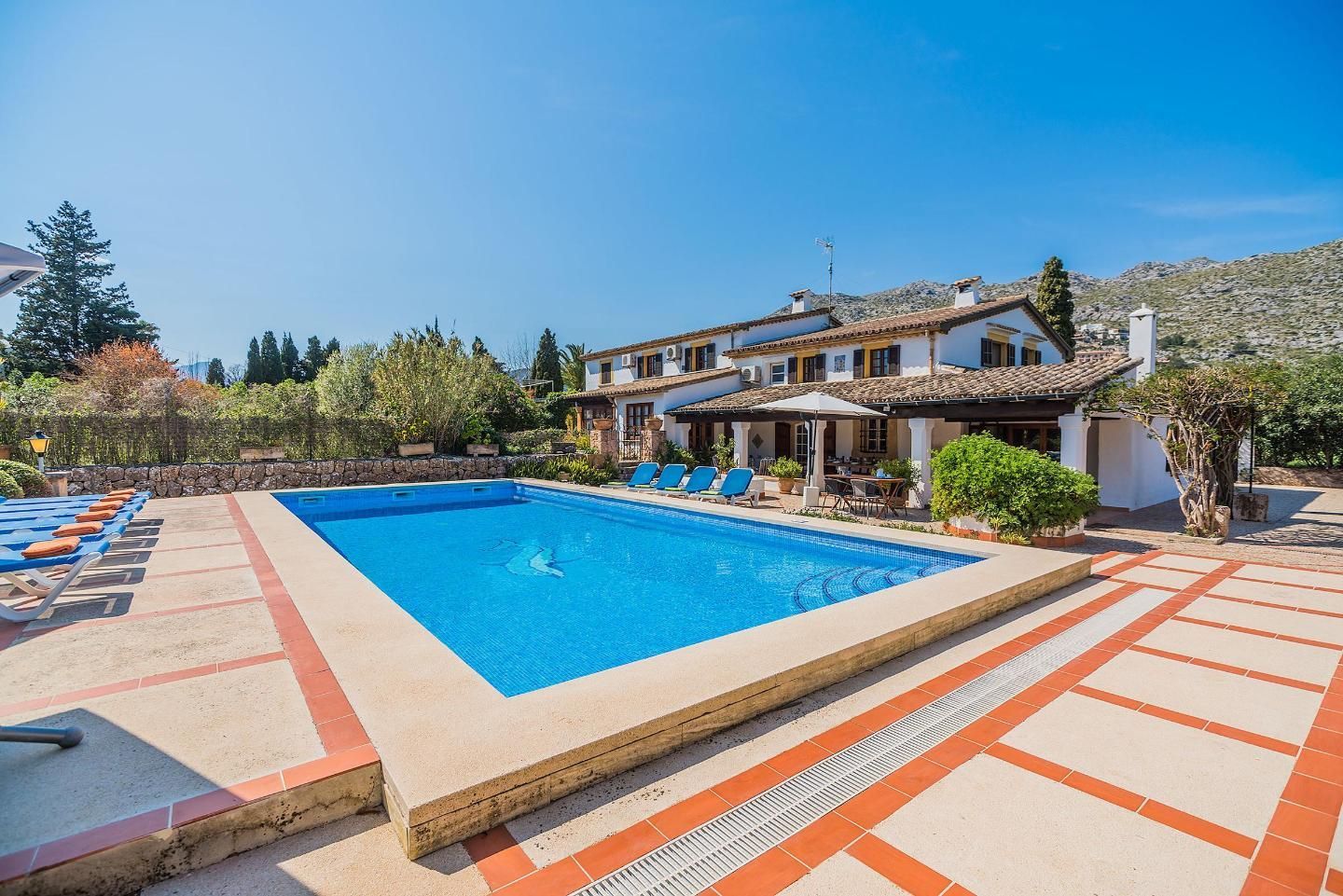 There is a large swimming pool in front of a house.