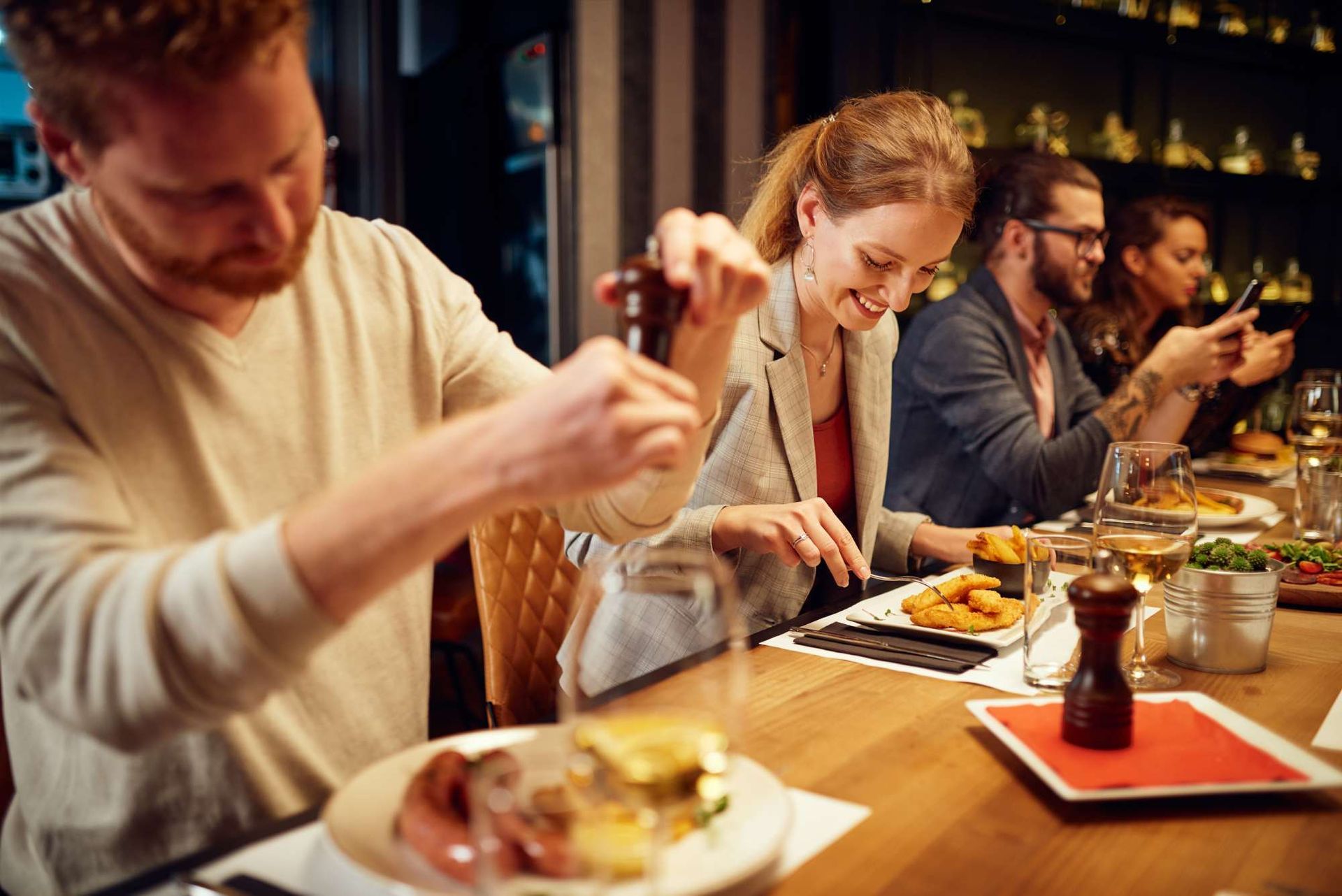 A group of people are sitting at a table in a restaurant eating food.