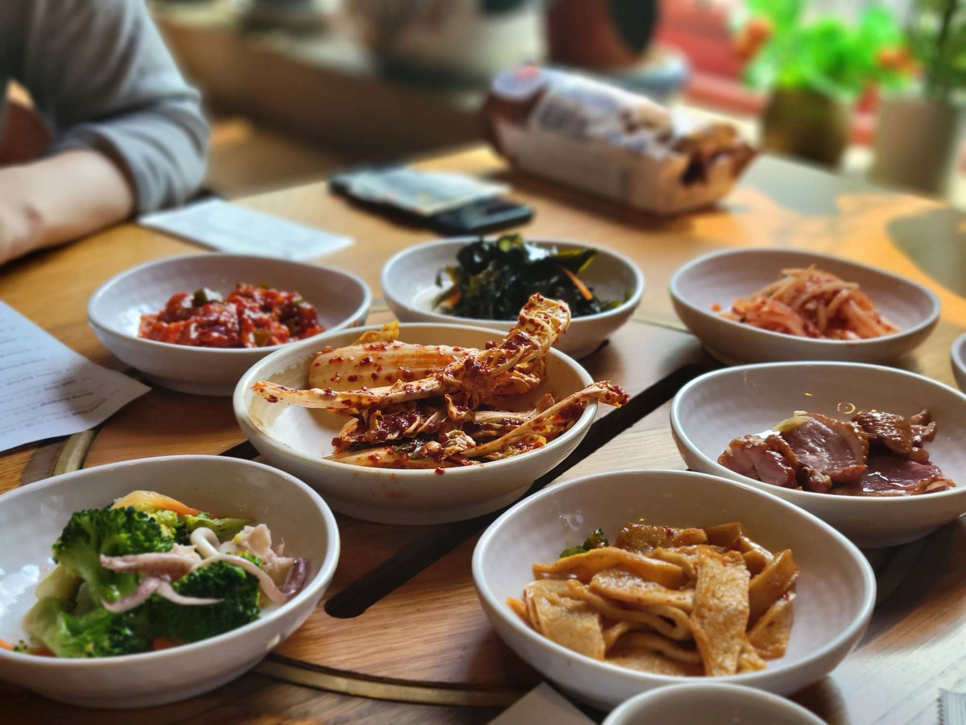 A table topped with bowls of food including broccoli and meat