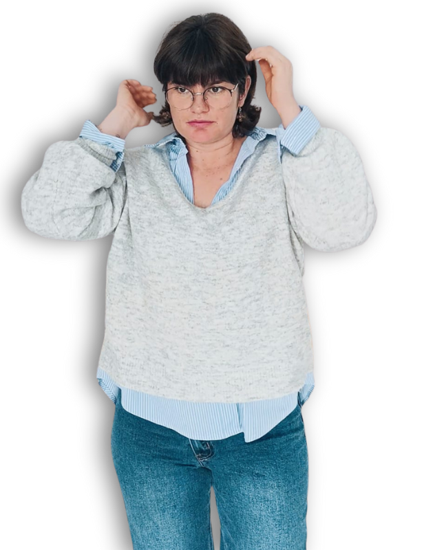 Una mujer que lleva un top corto y unos vaqueros azul claro.