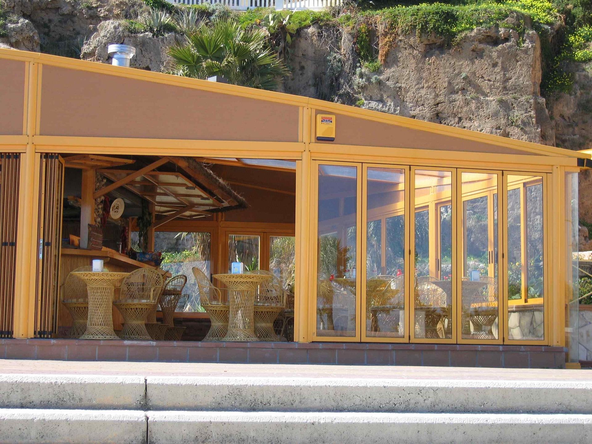 Un edificio con muchas ventanas, mesas y sillas.