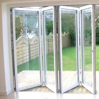 Una habitación con muchas ventanas y una valla al fondo.