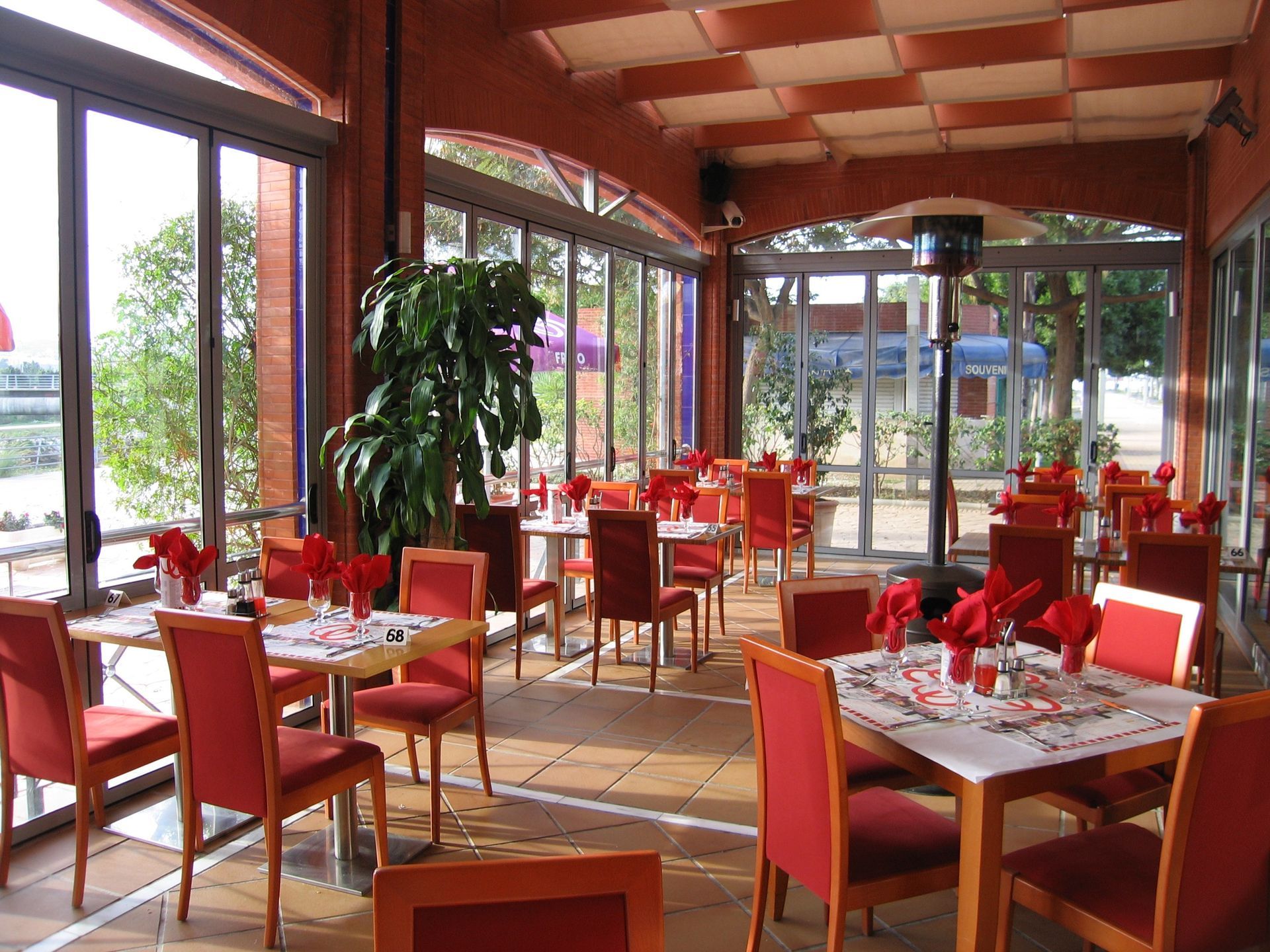 Un restaurante lleno de mesas y sillas con servilletas rojas.