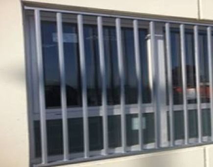 Una ventana con una valla metálica a su alrededor en un edificio.