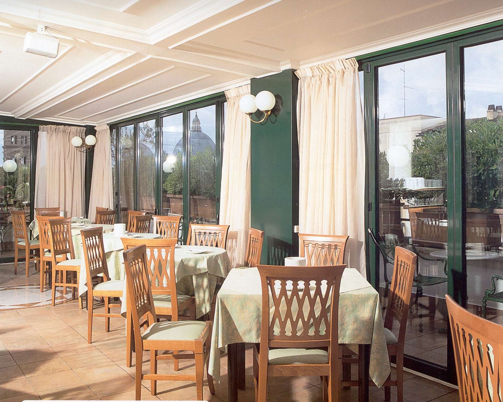 Un restaurante con mesas y sillas y muchas ventanas.