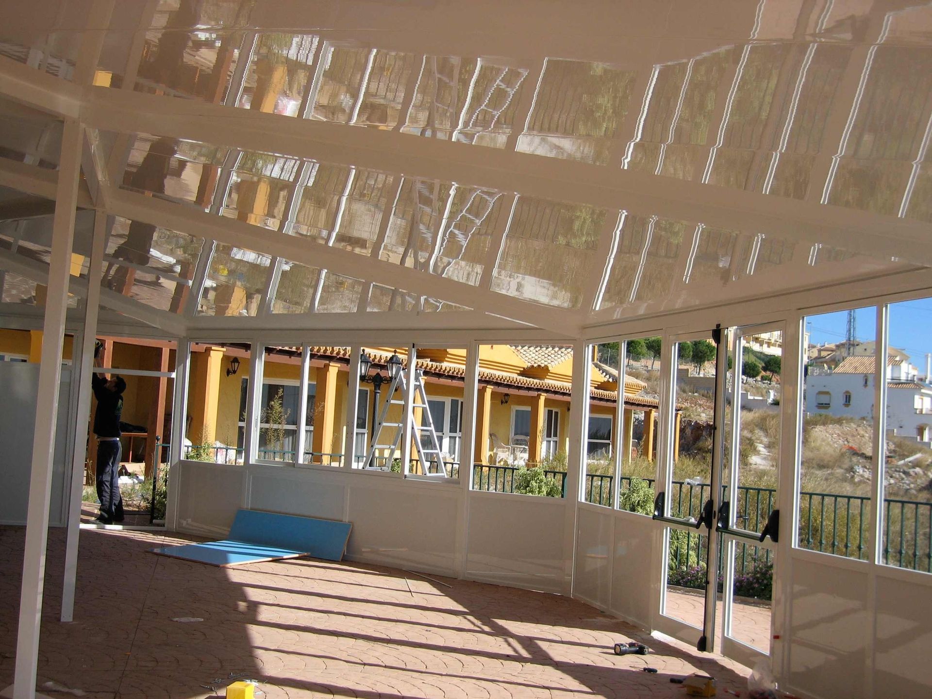 Una habitación con muchas ventanas y un reflejo de un edificio.