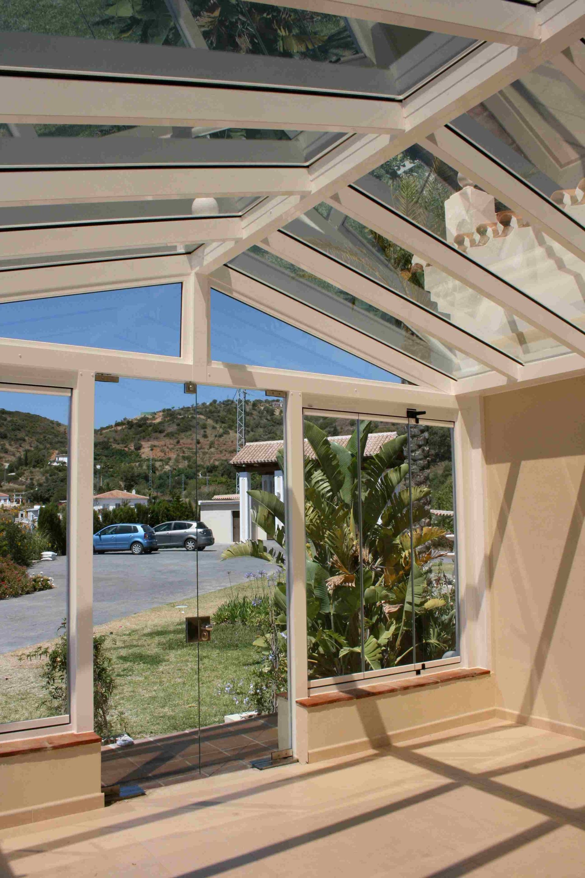 Una habitación con techo de cristal y muchas ventanas.