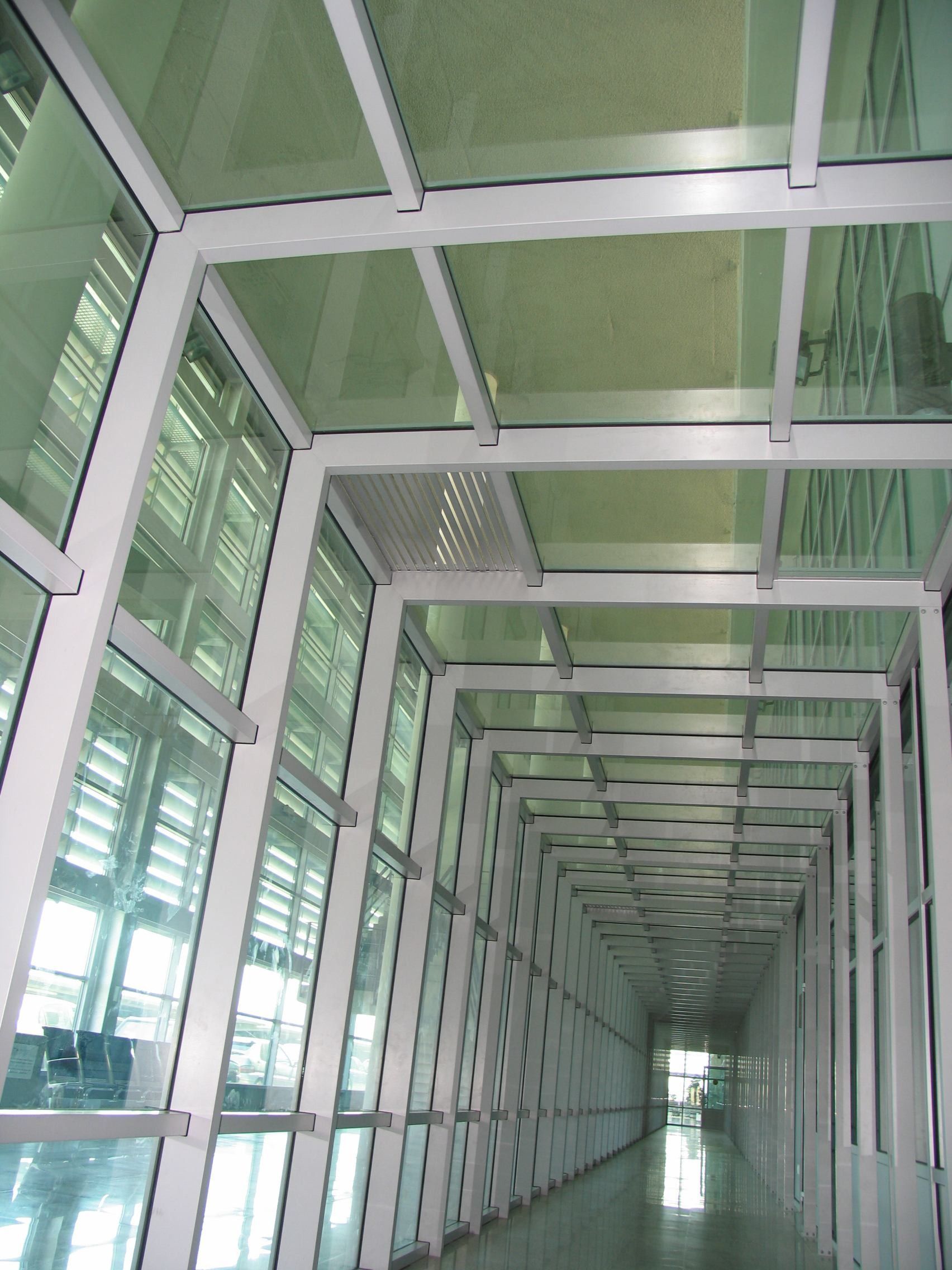 Un largo pasillo con muchas ventanas y un techo de cristal.
