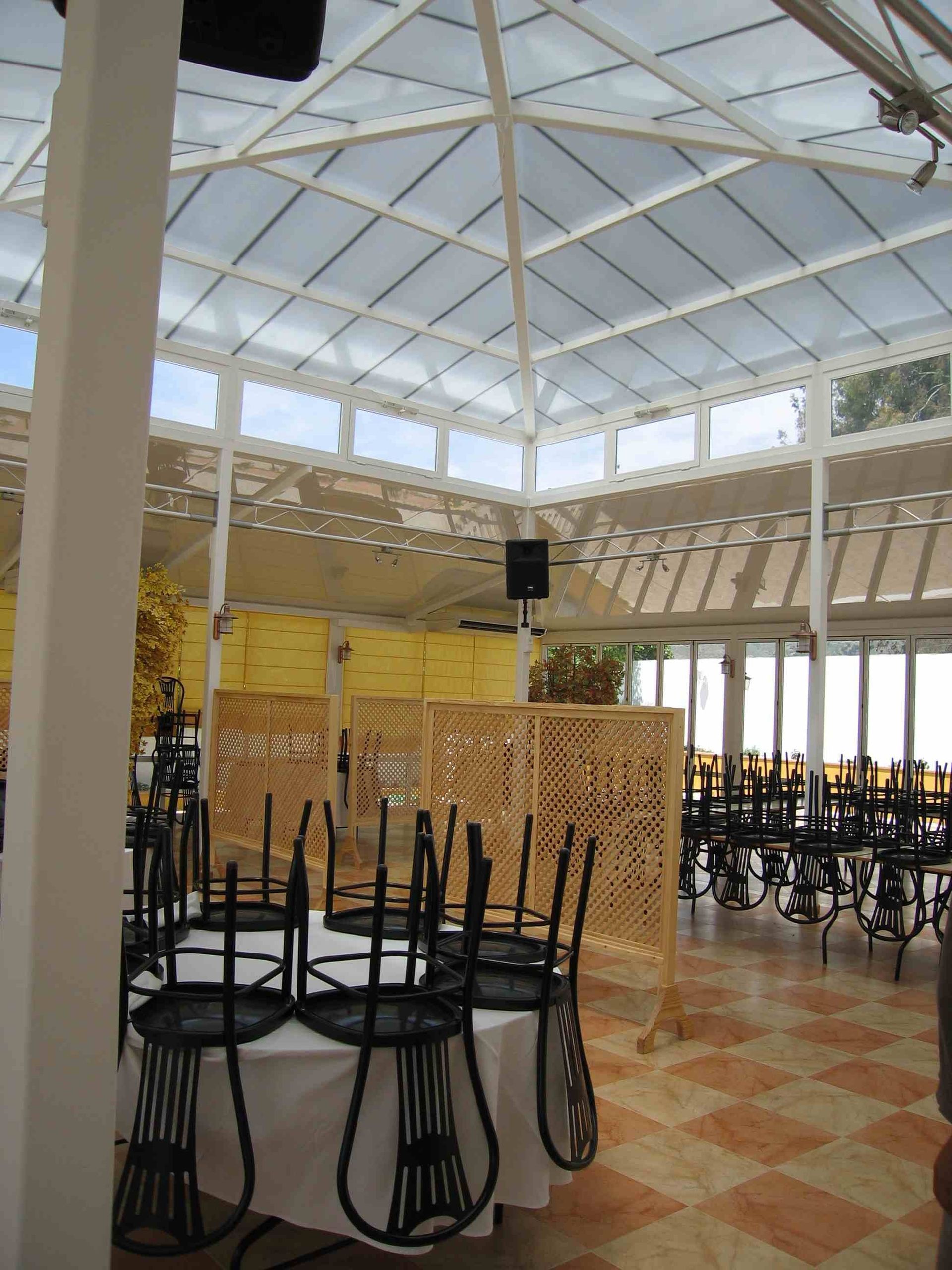 Mesas y sillas están apiladas una encima de otra en una habitación grande.