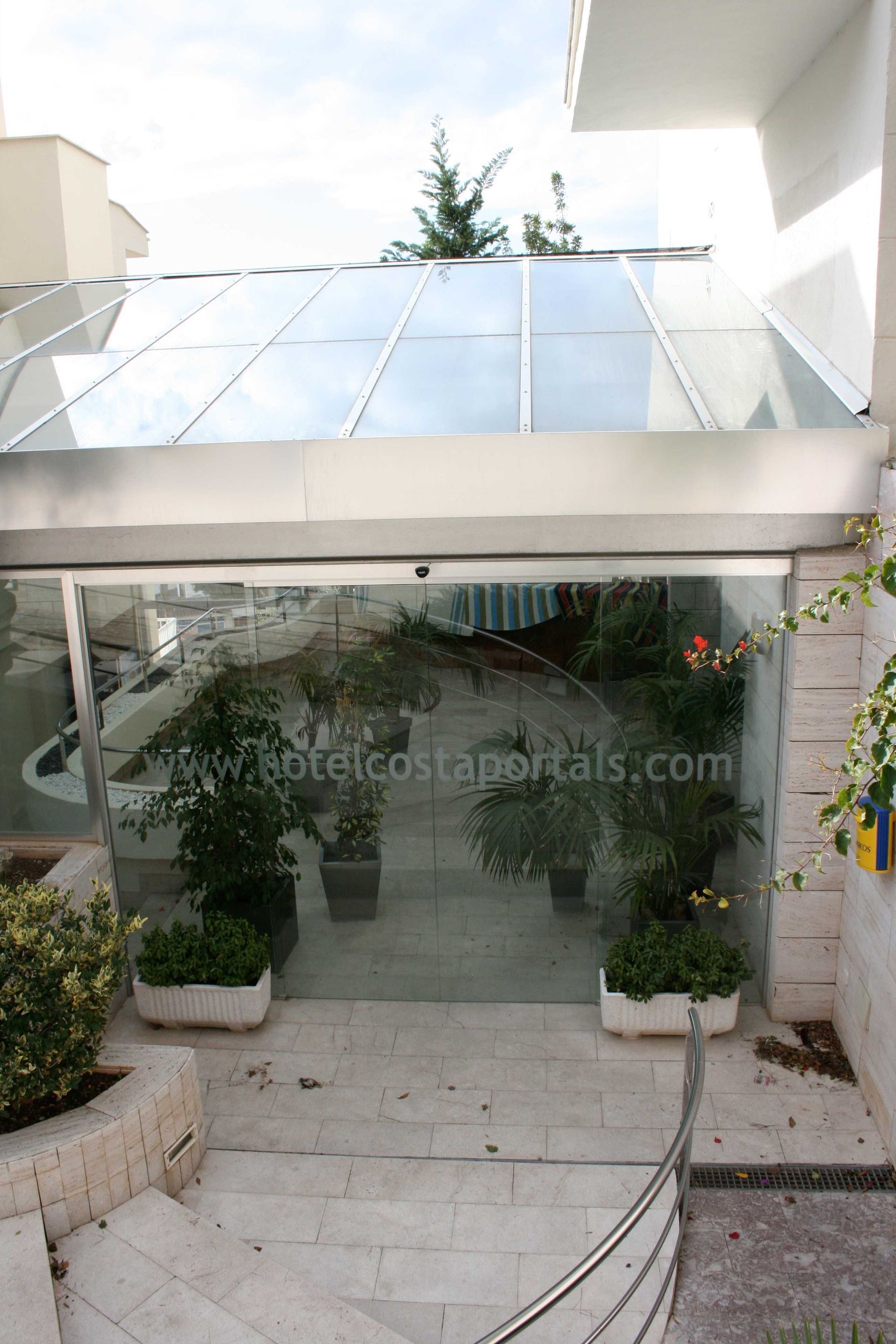 Un edificio con una puerta corrediza de vidrio y escaleras.