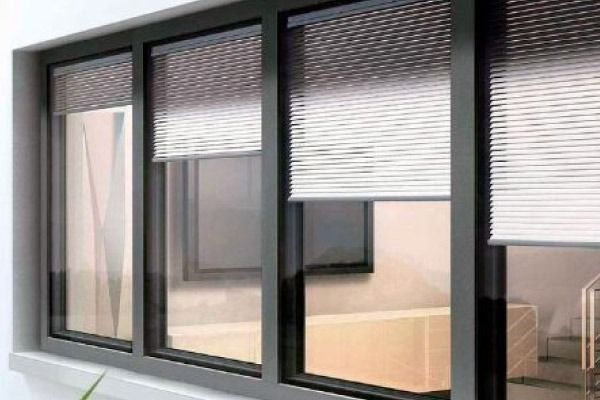 Una ventana con persianas y una escalera al fondo.