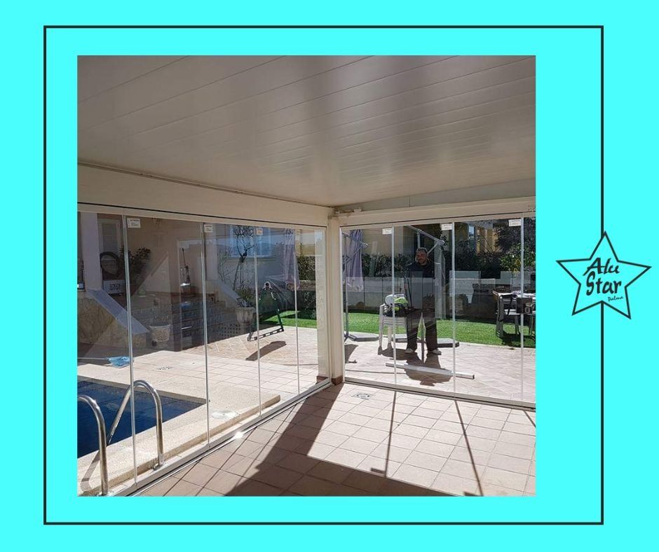 Una imagen de un patio con puertas corredizas de vidrio que conducen a una piscina.