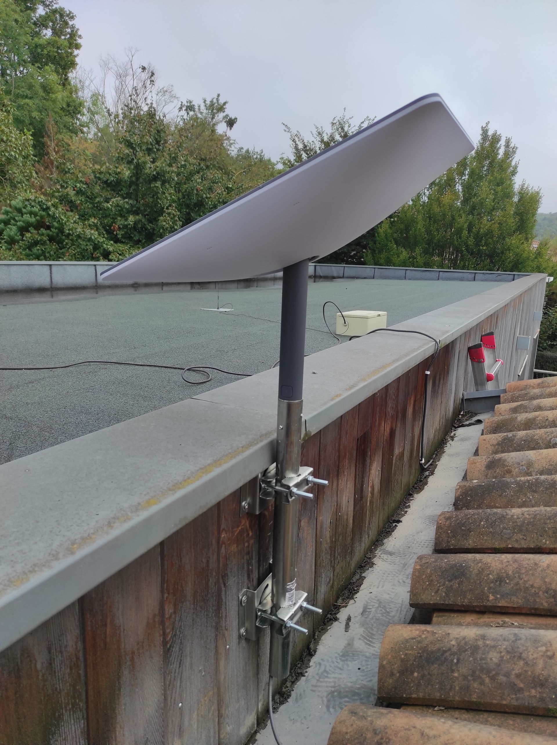 Un kit satellite de couleur blanche installé sur une pelouse