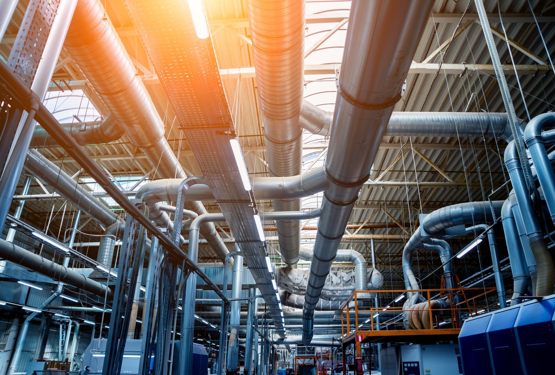 Eine Fabrik mit vielen Rohren, die von der Decke hängen.