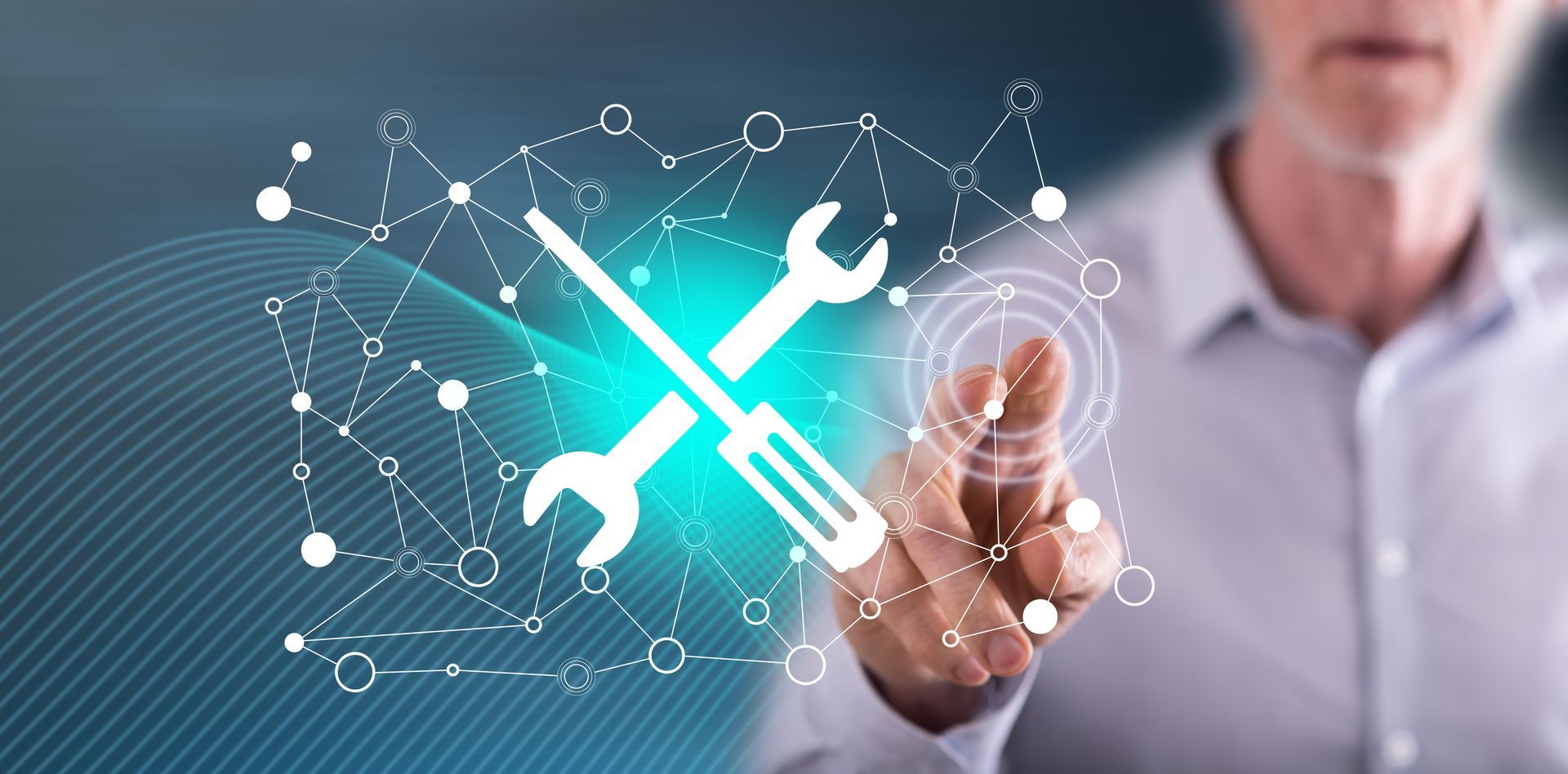 Ein Mann zeigt auf ein Schraubenschlüssel- und ein Schraubenzieher-Symbol auf einem Bildschirm.