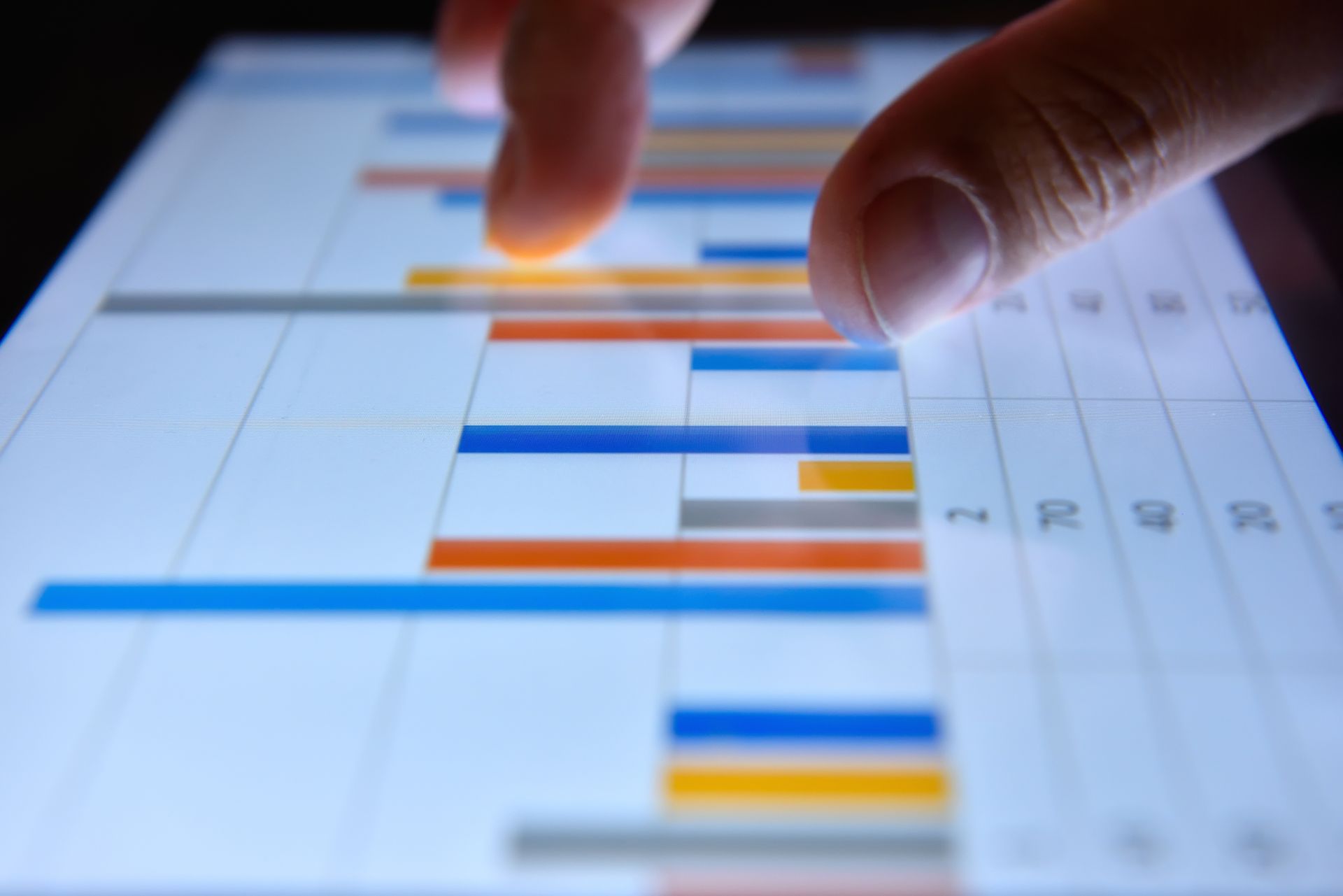 Eine Person zeigt auf ein Diagramm auf einem Tablet.