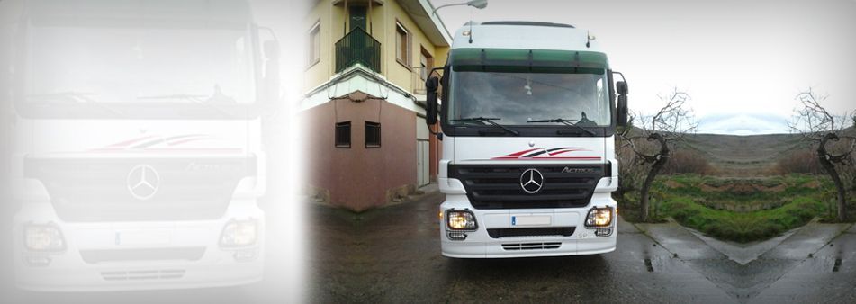Un camión Mercedes está estacionado frente a una casa.