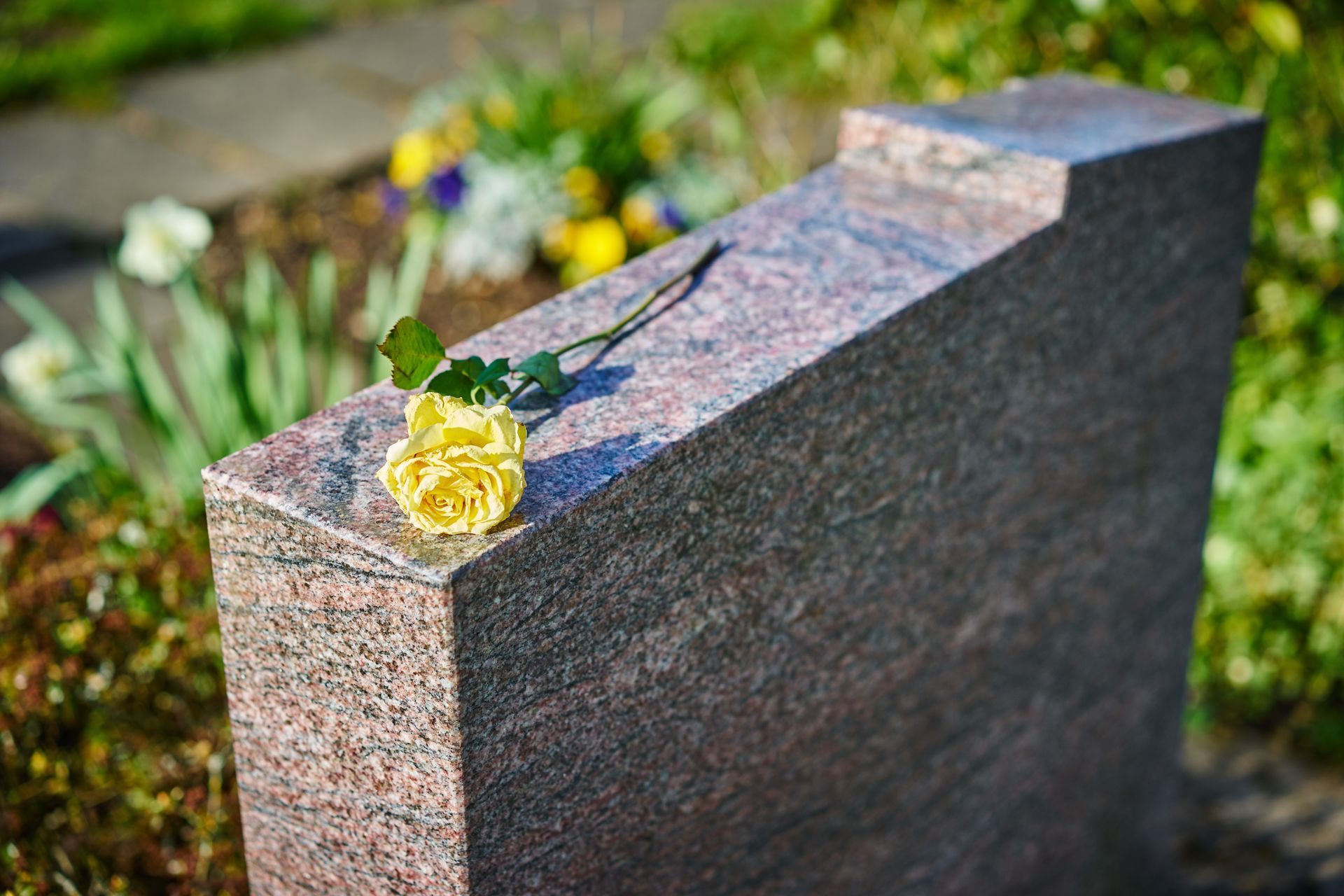 Pierre tombale avec une fleur jaune