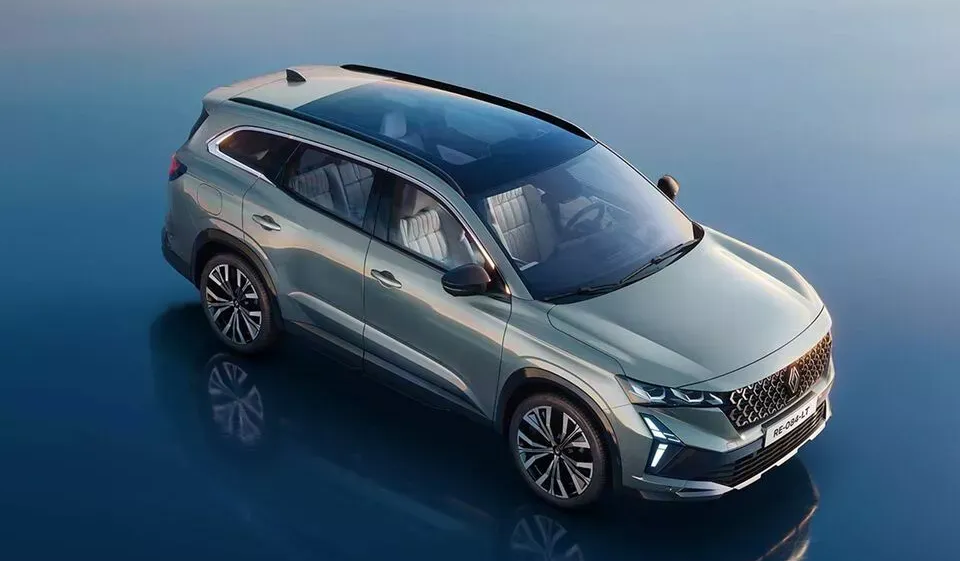 Un SUV Renault vert clair avec un toit panoramique en verre, vu d'un angle élevé sur un fond bleu réfléchissant.