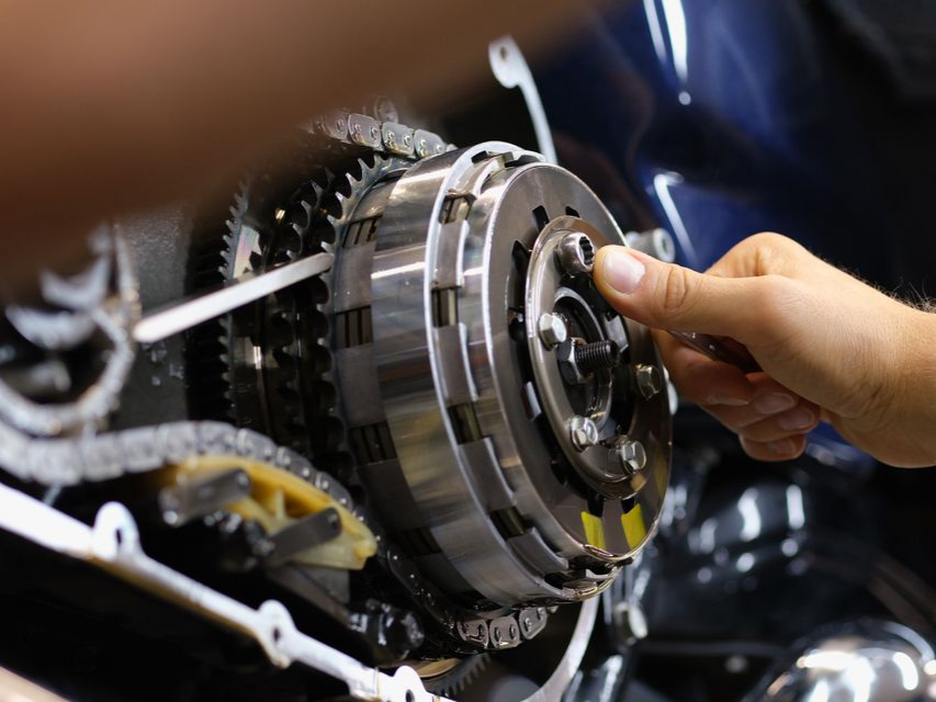 Main qui répare un moteur de voiture