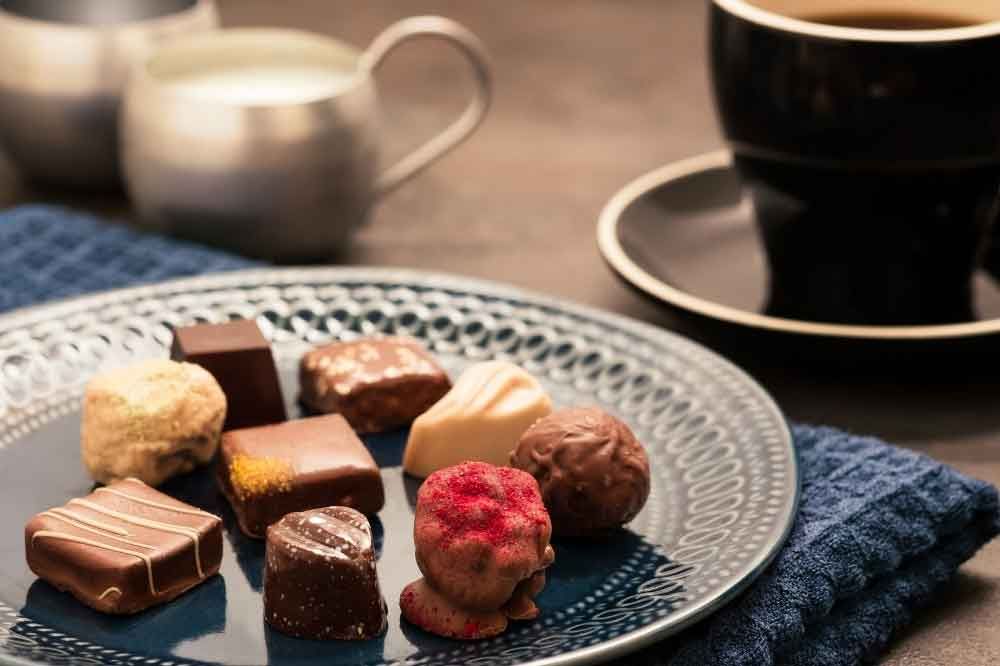 chocolate sitting on plate with coffee