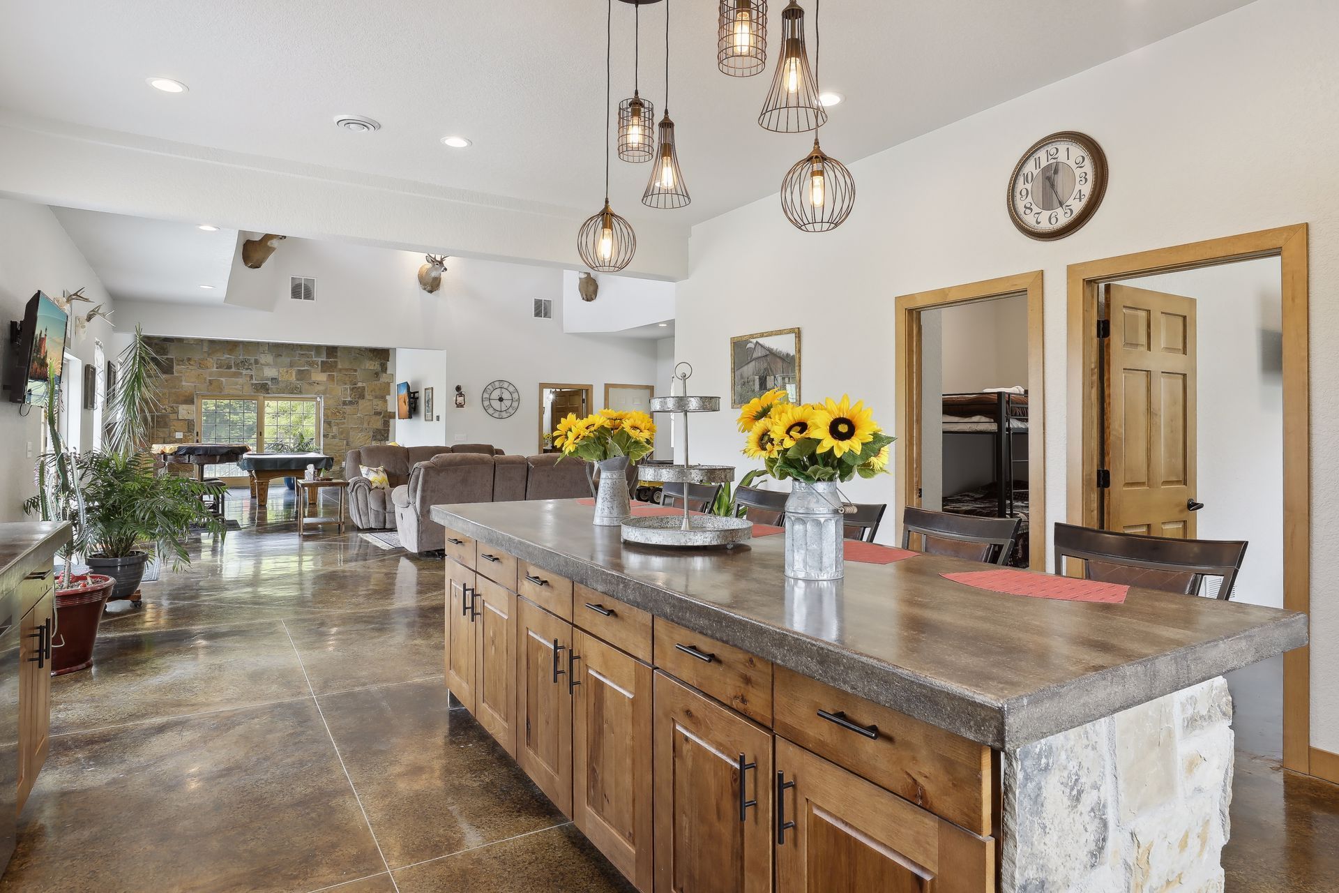 A kitchen with a large island and a clock on the wall.