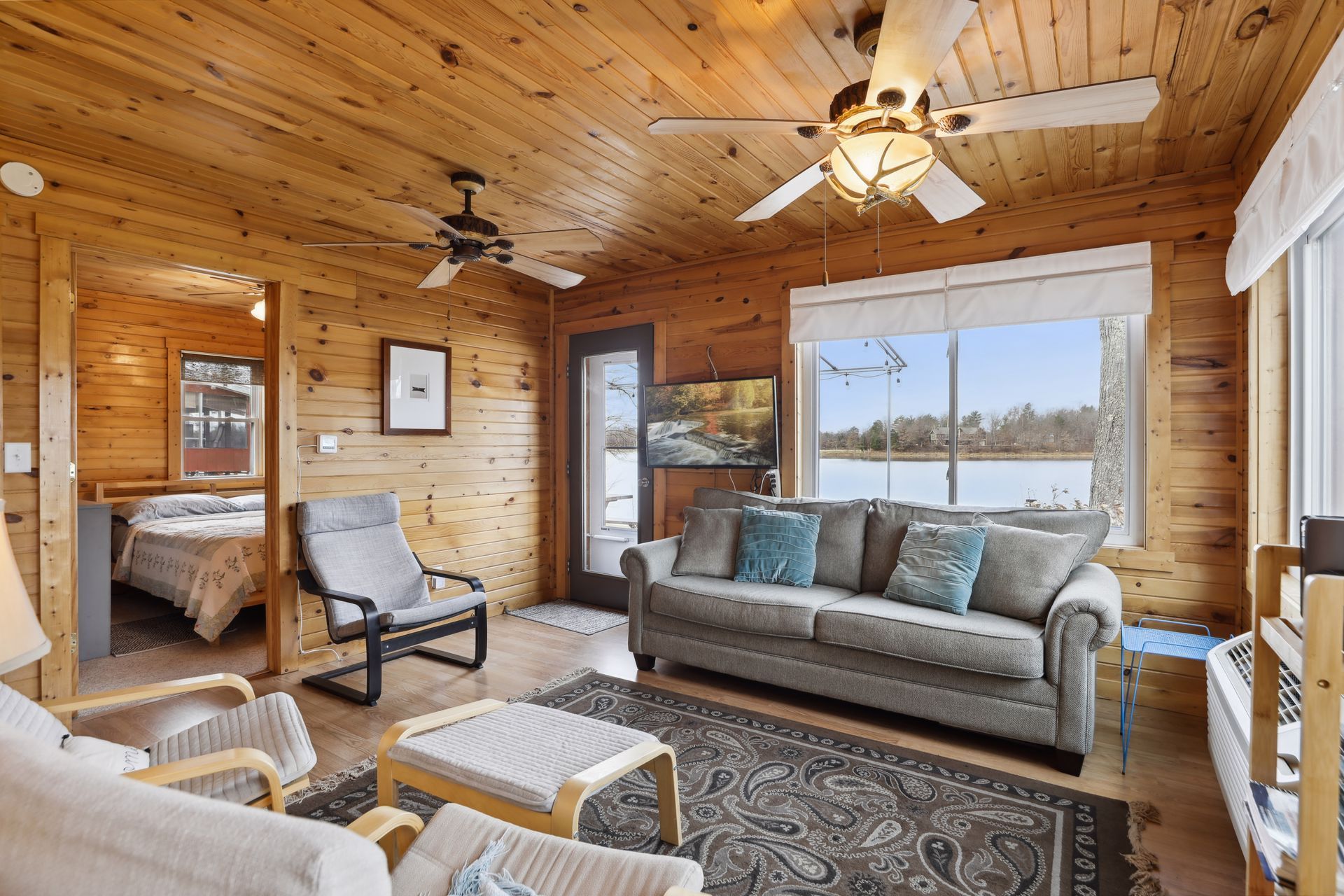 A living room with a couch , chairs , and a ceiling fan.