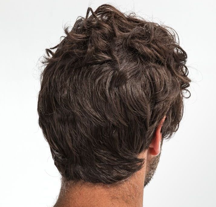 La parte posterior de la cabeza de un hombre con cabello rizado y barba.