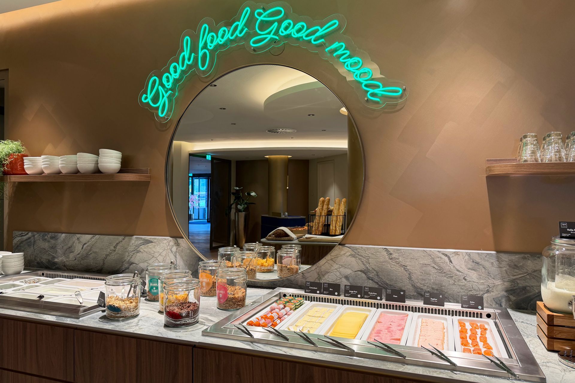 Een drielaags buffet met fruit en yoghurt op een marmeren toonbank in een restaurantgedeelte van een hotel.