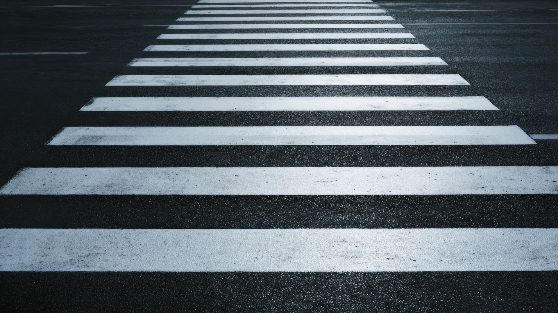 Passage piéton, bandes blanches peintes sur la chaussée asphaltée.