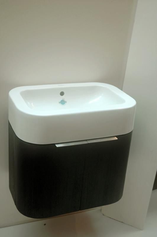 Ein Waschbecken im Badezimmer mit einem schwarzen Schrank darunter